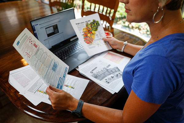 female worker looking at papers                                    and a                                    laptop